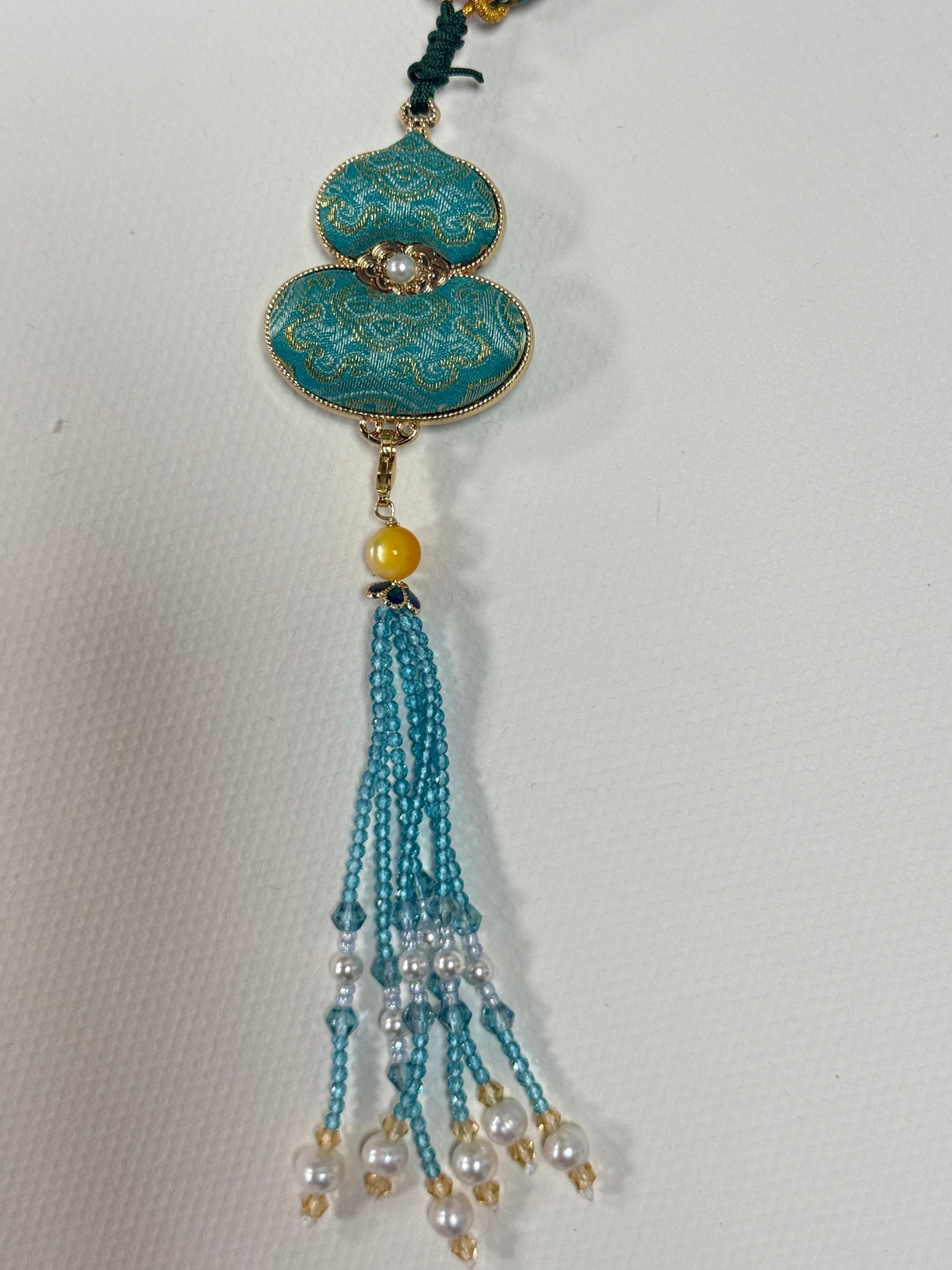 Handmade Song Brocade Gourd Pendant Necklace: Handmade Song Brocade Gourd Pendant Necklace This unique pendant necklace features a traditional Chinese gourd-shaped charm crafted with exquisite Song Brocade (Song Jin) silk fabric. The design blend