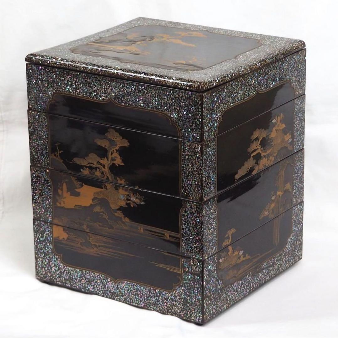From a previous family collection. Edo period. Four-tiered box, inlaid with mother-of-pearl,: From a previous family collection. Edo period. Four-tiered box, inlaid with mother-of-pearl, decorated with a landscape and pavilion motif. Height approximately 27.5 cm, width approximately 23 x 2.15 