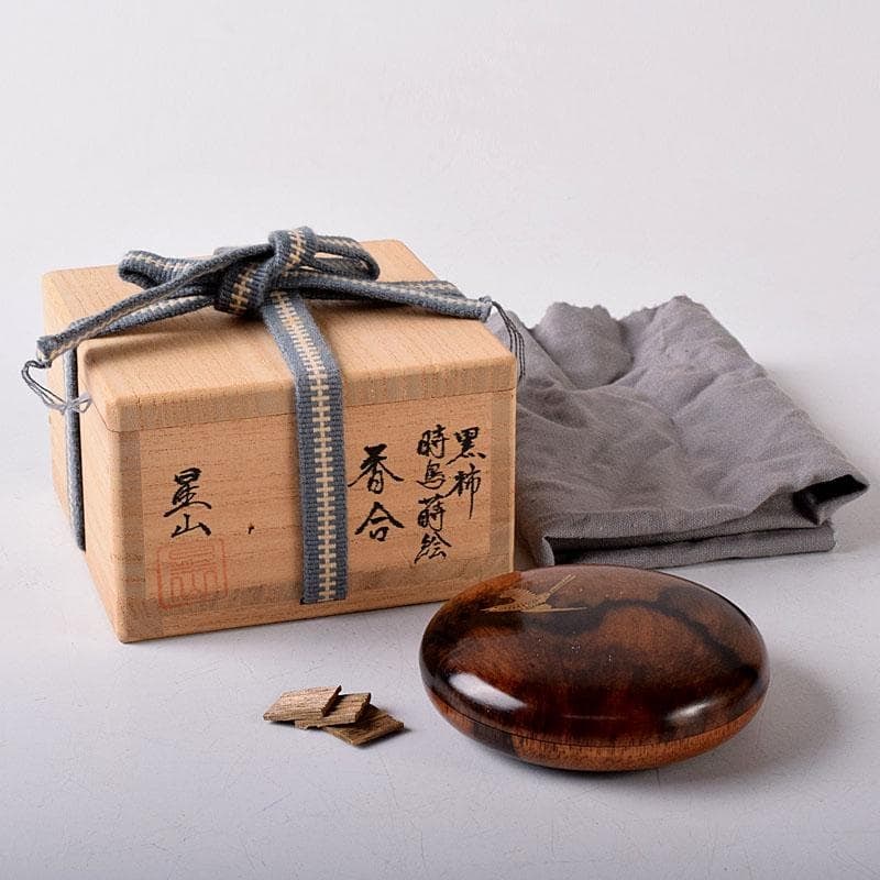 Tea Ceremony Utensils: A black persimmon wood incense box made by Nakabayashi Seizan, adorned with a: Tea Ceremony Utensils: A black persimmon wood incense box made by Nakabayashi Seizan, adorned with a design of a cuckoo bird, accompanied by the original box. Dimensions: Height approximately 2 cm, Wi