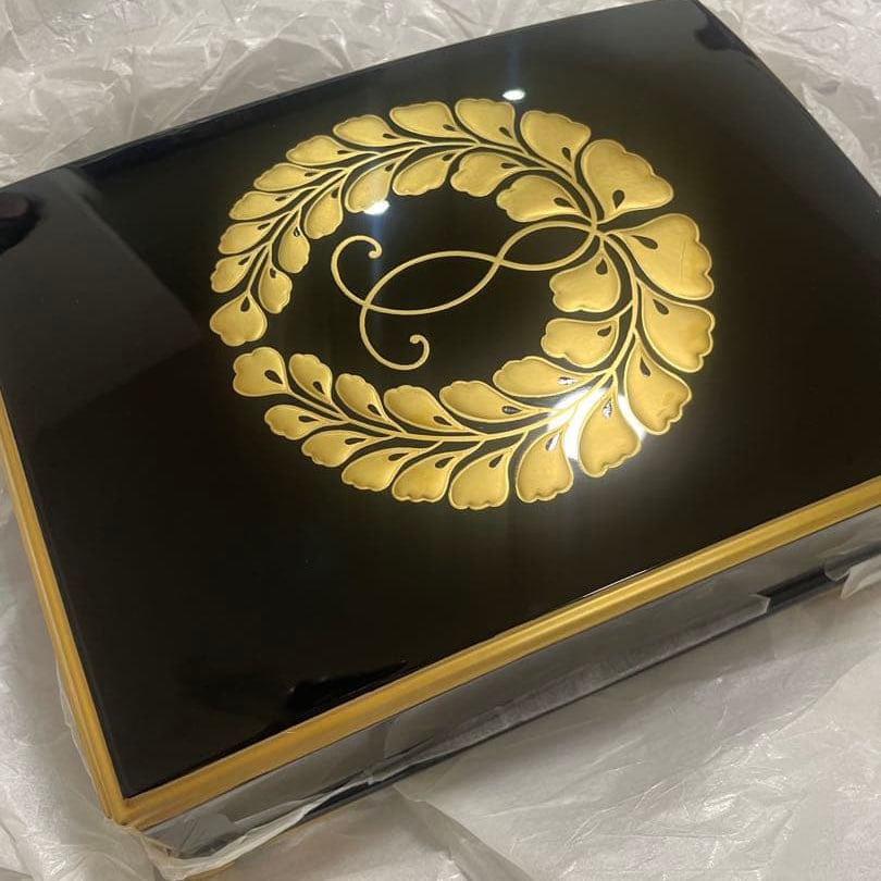 Lacquer document box decorated with gold leaf patterns on a black lacquer ground.: A lacquered document box with a black base and gold leaf pattern. Design: Black background adorned with a gold leaf motif and infinity symbol. Decoration: Sides embellished with gold. Interior: Glossy