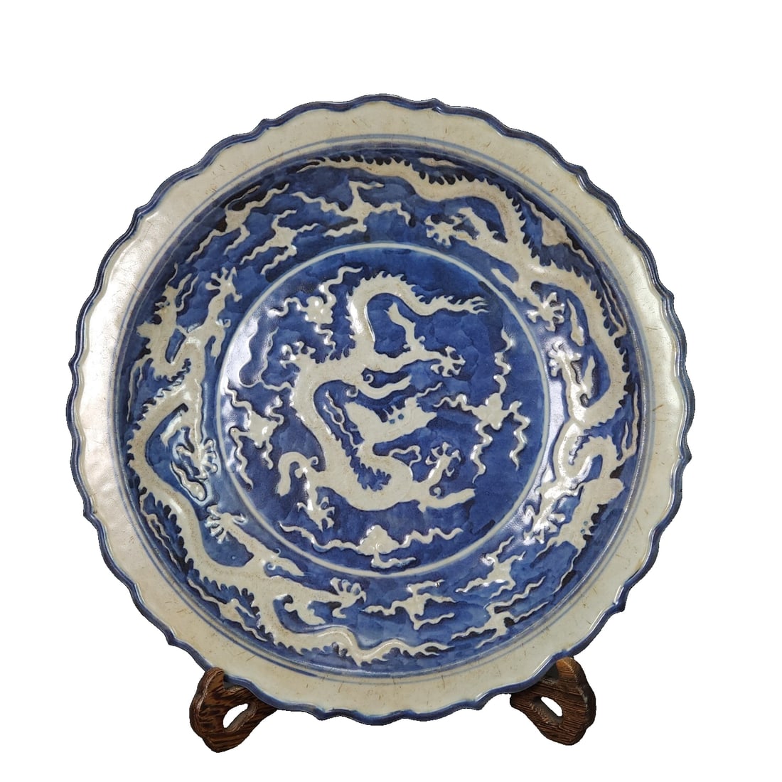 Blue and white porcelain plate with dragon design from the Wanli period of the Ming Dynasty.: This is a blue and white porcelain plate from the Ming Dynasty, made in the Wanli period. It features a design of a dragon with reserved white spaces, with a height of 6 cm and a diameter of 34 cm. Th