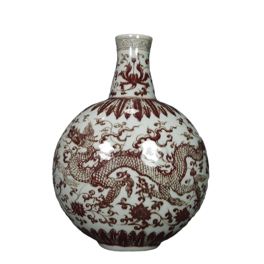 Ming Dynasty Xuande period copper-red glazed dragon pattern vase: A Ming Dynasty Xuande period underglaze red dragon pattern vase, with a flat round bulging body, a short neck flaring outward, and a proportionate and simple design. The glaze is as white as jade, wit
