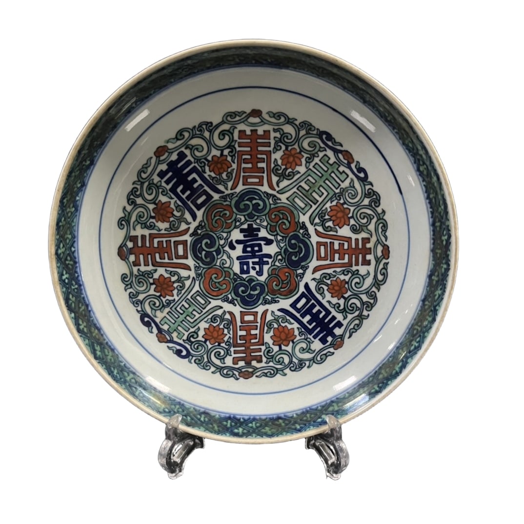 Qing Dynasty large plate with Shou character and intertwined lotus pattern decoration made by: This plate is a large plate made by Yishantang in the Qing Dynasty, with a diameter of 29.5 centimeters and a height of 6.8 centimeters. The shape of the plate is dignified and heavy, with an ancient
