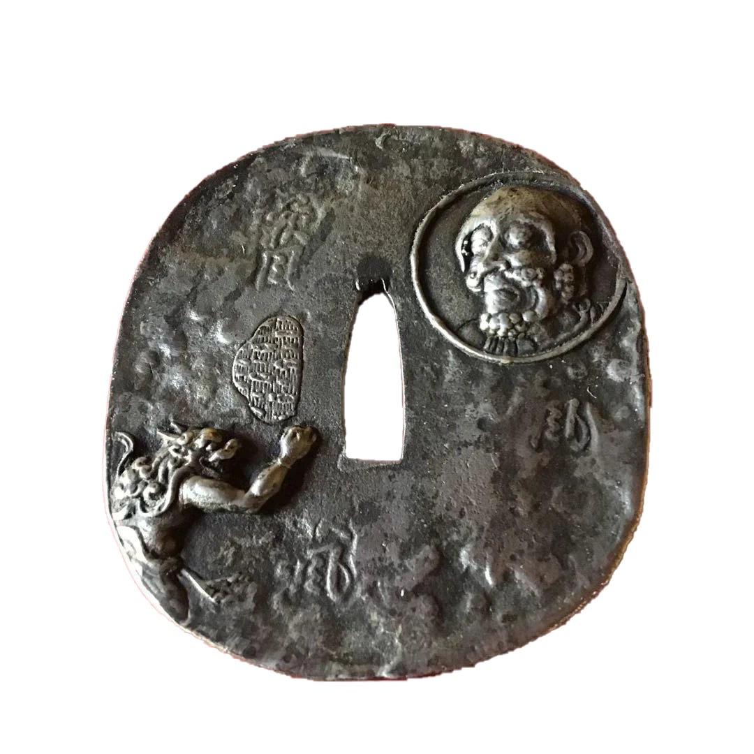 The hilt of the sword is engraved with images of a Buddha and two demons.: The hilt guard of the sword is engraved with the image of a Buddha and two demons. Dimensions (mm) Height 82 Width 76 Thickness 7