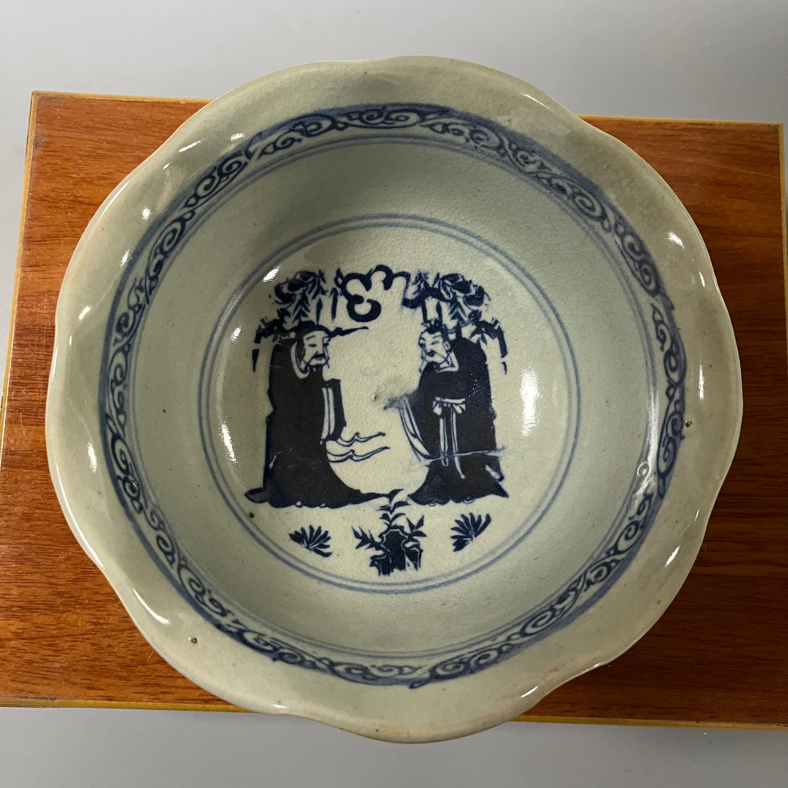 Ming Dynasty Xuande Period Blue and White Porcelain Bowl with Figure Design: This Ming Dynasty Xuande blue-and-white porcelain bowl with a floral design features figures. It measures approximately 18cm in diameter and 8cm in height. The floral rim (or sunflower rim) is gracefu