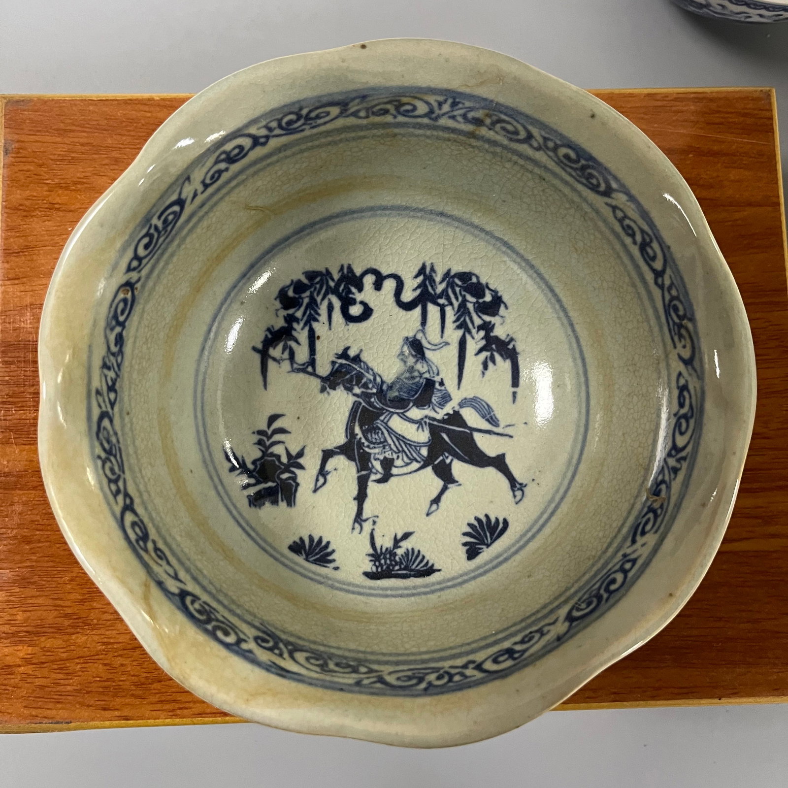 Blue and white porcelain bowl with flower-shaped rim during the Xuande period of the Ming Dynasty: This Ming dynasty blue-and-white porcelain bowl with a floral narrative design measures approximately 18cm in diameter and 8cm in height. The bowl features a gracefully curved rim (or sunflower-shaped