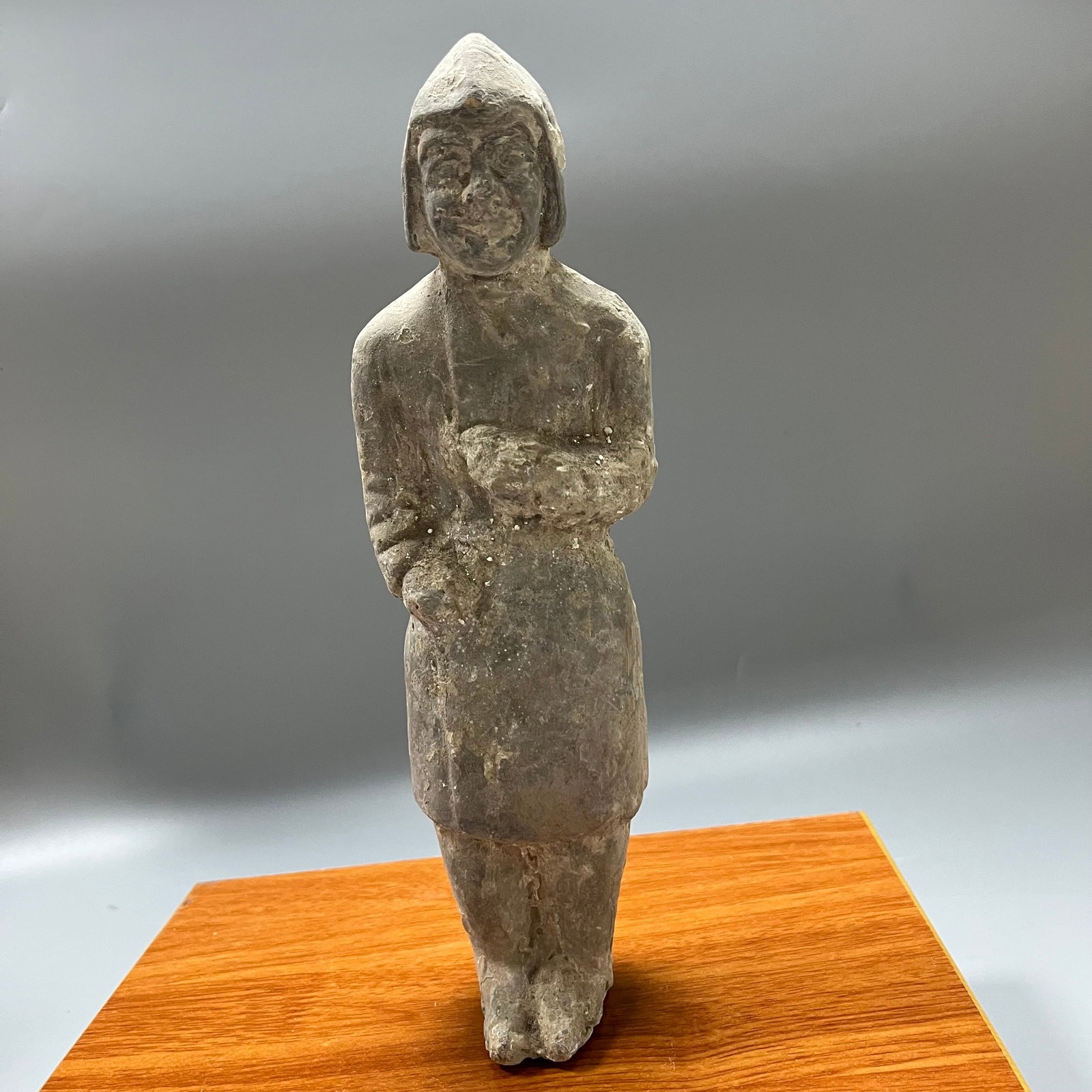 Han Dynasty gray pottery standing civil official figurine: This is a typical Han Dynasty gray pottery standing figurine, measuring 27 x 8 cm. The figurine wears a flat-topped double-horned hood, a popular style during the Han Dynasty. Its face is full, with s