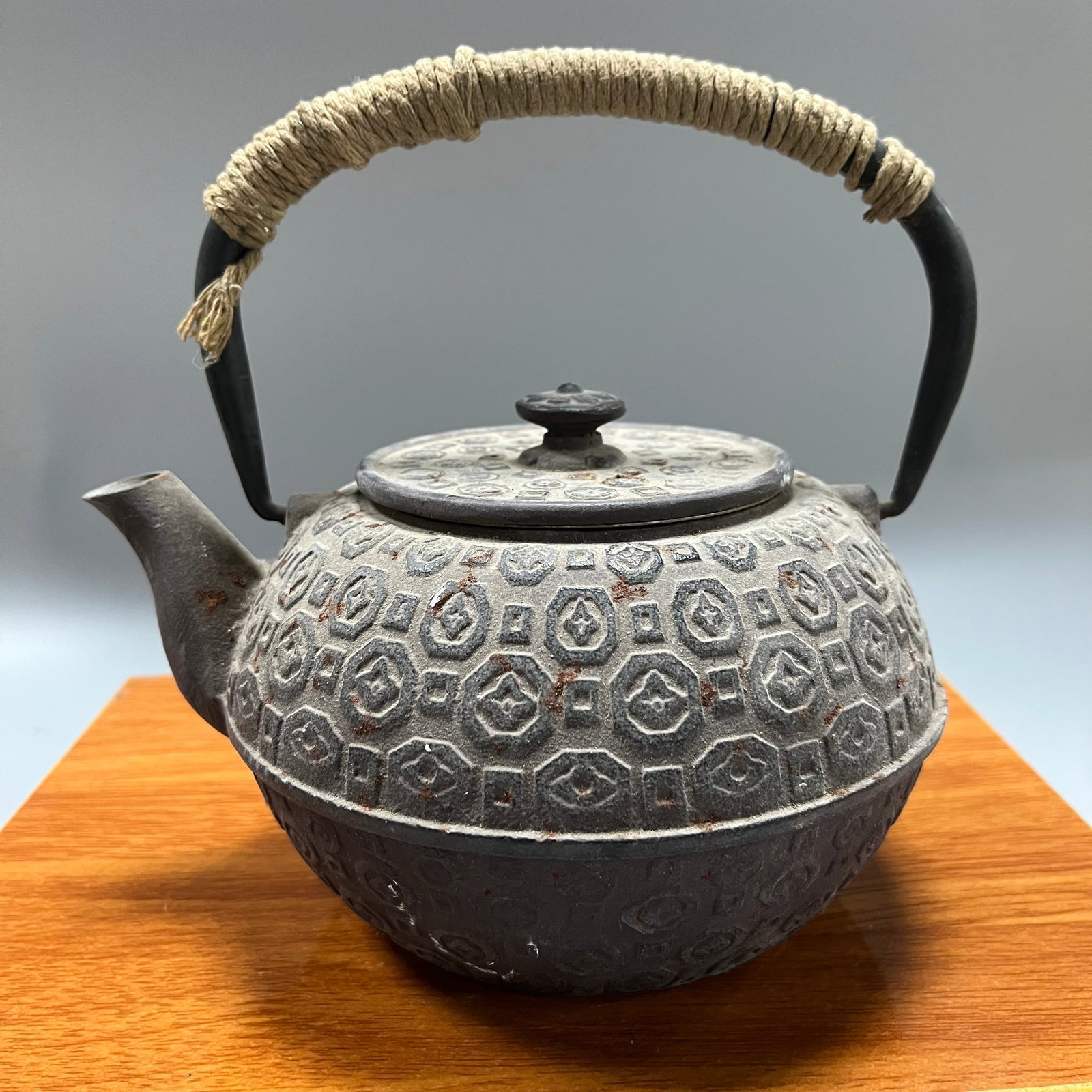 Late Qing Dynasty Cast Iron Tea Pot with Swastika Pattern and Handle: Late Qing Dynasty Cast Iron Tea Kettle with Swastika Pattern and Handle, 18x19 cm.This tea kettle is robust in shape and finely decorated. The cast iron surface has developed a warm, brownish patina, 