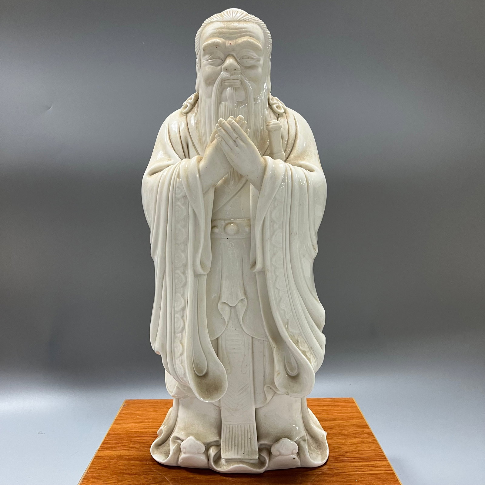 Dehua Kiln White Porcelain Standing Statue of Confucius: A standing statue of Confucius made of Dehua white porcelain, 42 x 17 cm. The entire piece is covered in an ivory-white glaze, the glaze itself lustrous and jade-like. Confucius wears a traditional to