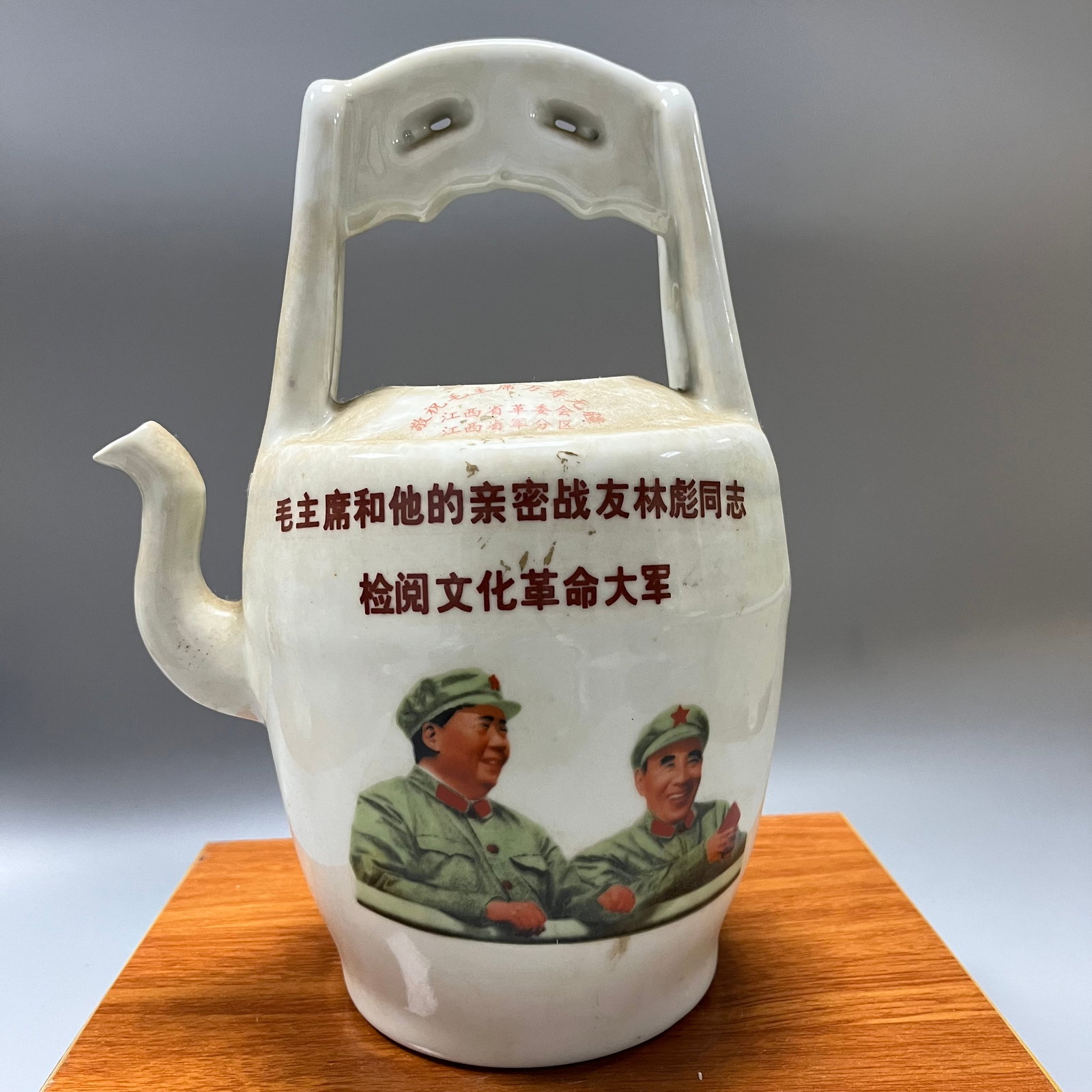 Teapot with handle during the Cultural Revolution: This is a typical political propaganda porcelain teapot made in 1968 during the Cultural Revolution, exhibiting distinct characteristics of the era. It measures 28 x 20 cm. The teapot is cylindrical w