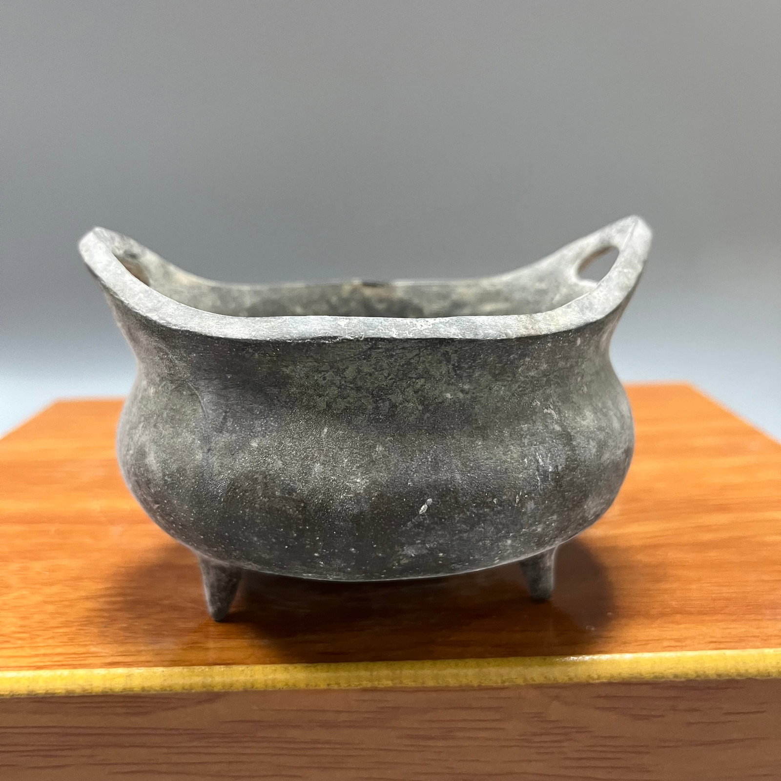 Three-legged incense burner made during the Xuande period of the Ming Dynasty: A three-legged incense burner made during the Xuande reign of the Ming Dynasty, measuring 6 x 12 cm. The base bears a neat, square, raised seal script inscription reading "Made in the Xuande reign of