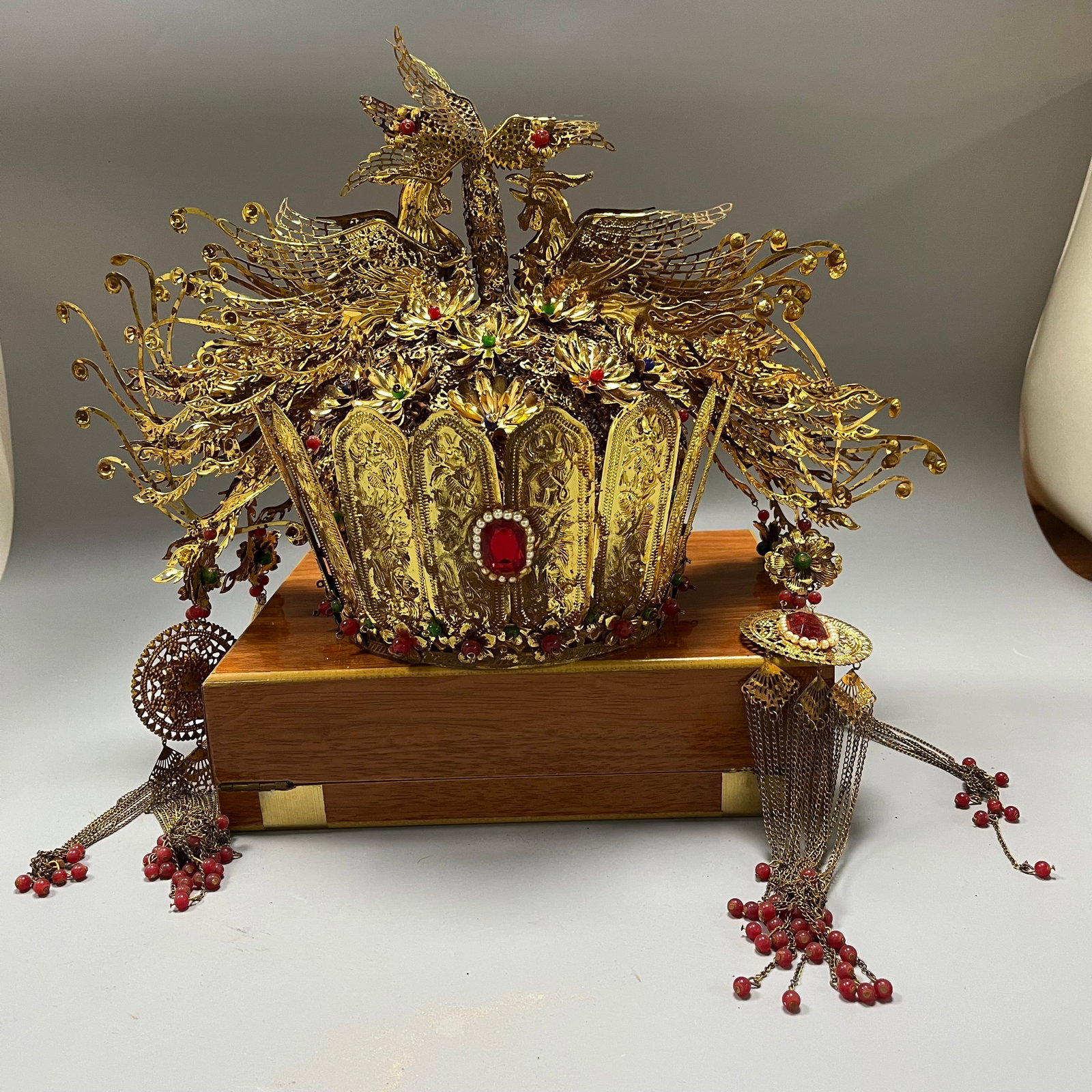 A Qing Dynasty court-style gold phoenix crown, inlaid with kingfisher feathers and precious stones,: A Qing Dynasty Imperial Phoenix Crown, 25 x 44 cm, featuring a dragon and phoenix design achieved through gold filigree, kingfisher feather inlay, and gemstone setting. This crown, crafted in the Qing