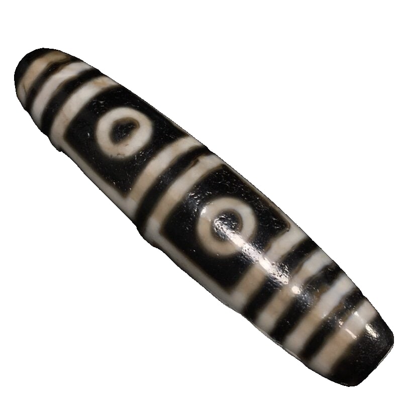 Tibetan old material [four-eyed Dzi beads]: Four-Eyed Dzi Bead from Aged Tibetan Material Size: 68*16mm, Weight: 27g This bead, a sacred bead for kings and generals, dispels all harm from Rahu and demons. Witnesses are blessed with the