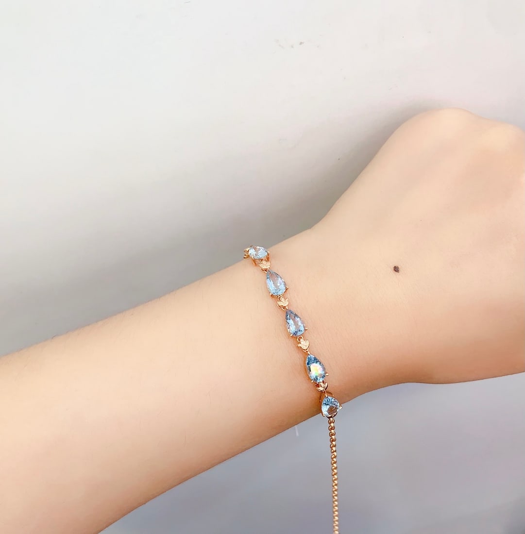 18K Gold Natural Aquamarine Bracelet: This bracelet is meticulously crafted in 18K gold, set with a natural aquamarine that exudes an elegant blue glow. Its simple design embodies noble elegance, suitable for any occasion. (Total weight