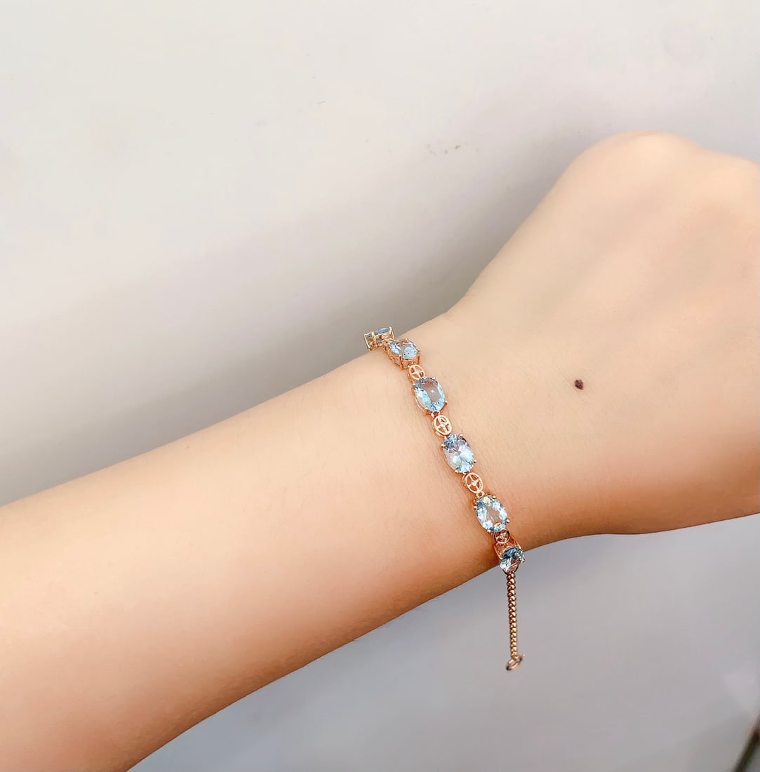 18K Gold Natural Aquamarine Bracelet: This bracelet is meticulously crafted in 18K gold, set with a natural aquamarine that exudes an elegant blue glow. Seven diamonds adorn it, adding a dazzling charm. The overall design is simple yet