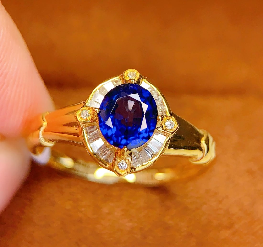 18K Gold Natural Sapphire Ring: This ring is meticulously crafted in 18K gold, set with a natural sapphire that exudes a captivating brilliance. The deep hue of the sapphire complements the 24 diamonds, showcasing a noble elegance.