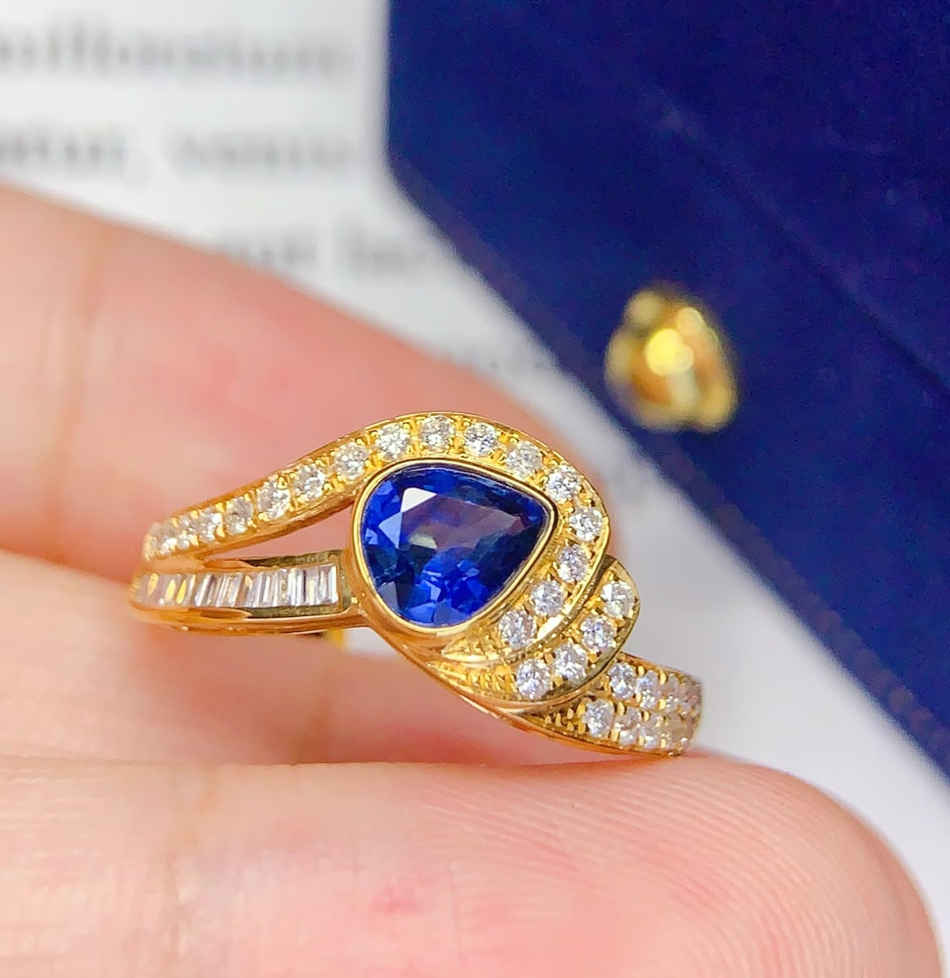 18K Gold Natural Sapphire Ring: This ring is meticulously crafted in 18K gold, set with a natural sapphire that exudes a captivating brilliance. The surrounding diamonds add a dazzling charm, with an overall design that is elegant