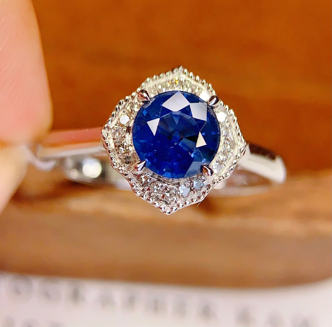 18K Gold Natural Sapphire Ring: This ring is meticulously crafted in 18K gold, set with a natural sapphire that exudes a captivating brilliance. The main stone's deep and pure blue is complemented by 20 sparkling diamonds,