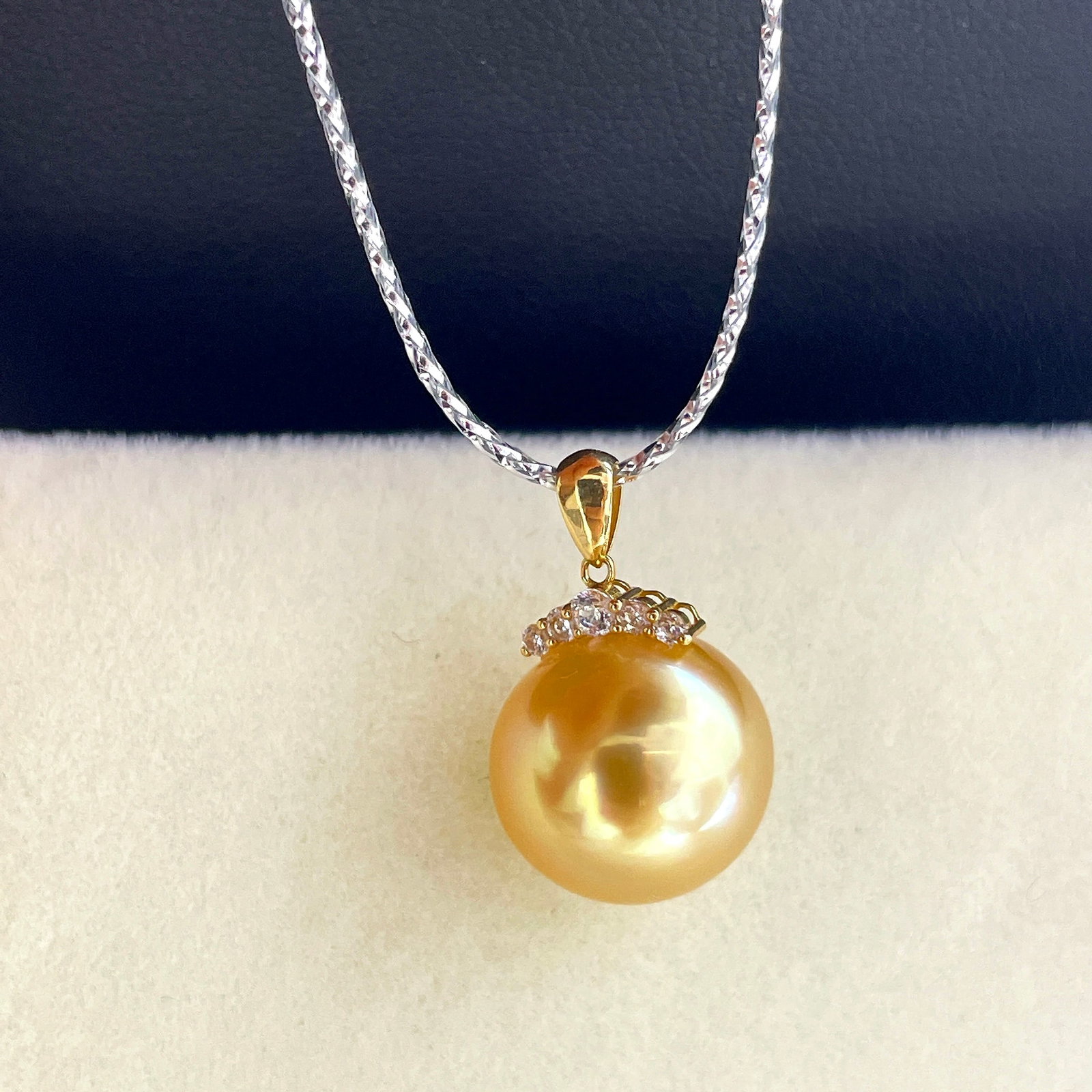18K Gold South Sea Golden Pearl Pendant: This pendant is crafted in 18K gold, featuring a South Sea golden pearl with a lustrous sheen, nearly flawless. The exquisite zircon eyelash clasp design adds elegance and uniqueness to the piece.