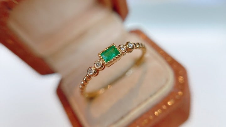 18K Gold Emerald Ring: This 18K gold emerald ring is elegantly designed, suitable for wearing alone or stacking, showcasing a unique style. The ring is lightweight and comfortable to wear, with the emerald's hue