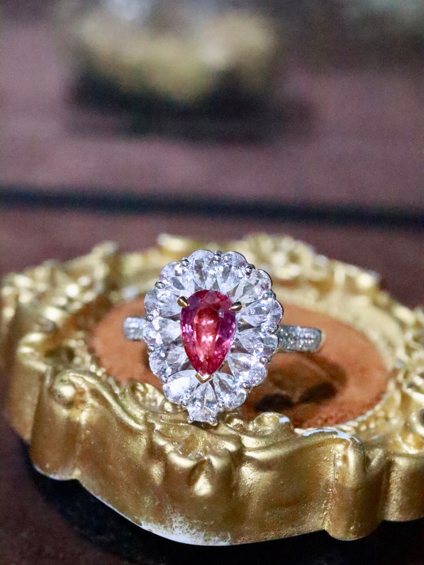 18K Gold Natural Unheated Padparadscha Ring: This ring, with its simple yet sophisticated design, exudes an aura of elegance. The unheated Padparadscha's hue is as captivating as a sunrise, complemented by exquisite diamonds, showcasing luxury.