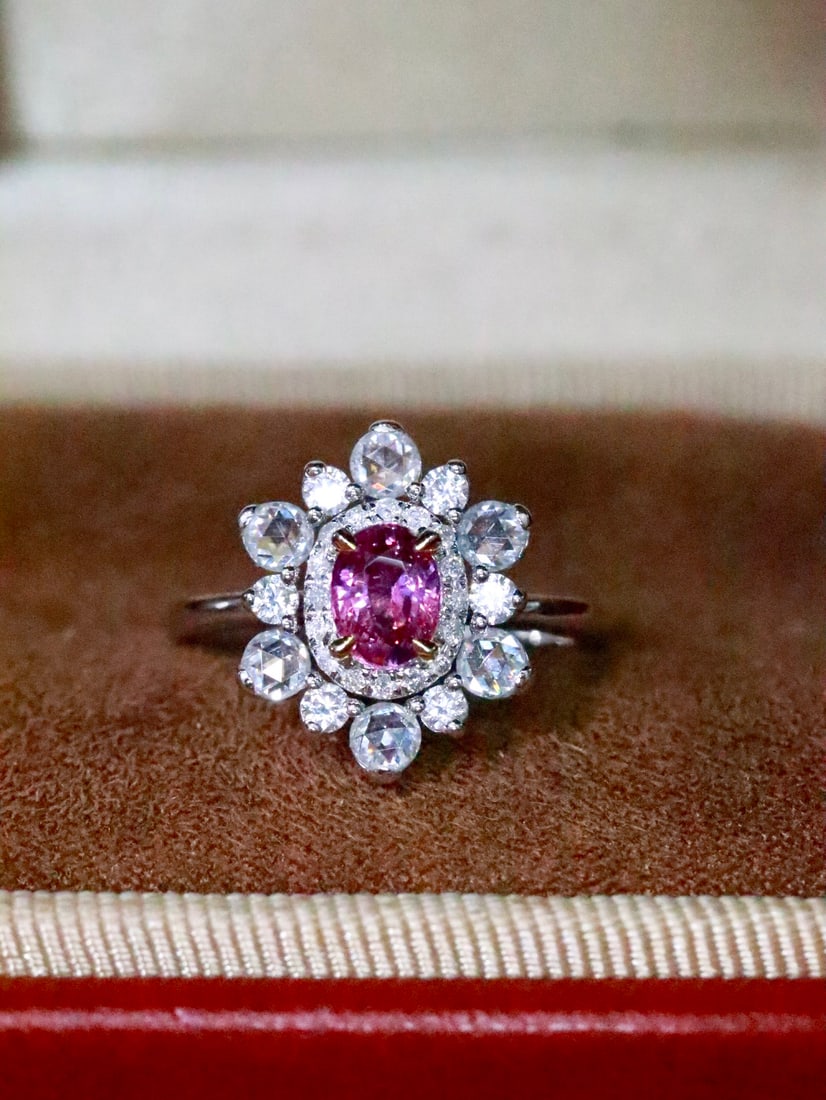 18K Gold Natural Unheated Padparadscha Ring: This ring showcases unparalleled luxury with its unique color and exquisite craftsmanship. The natural hue of the Padparadscha complements the dazzling brilliance of the diamonds. The texture of 18K g