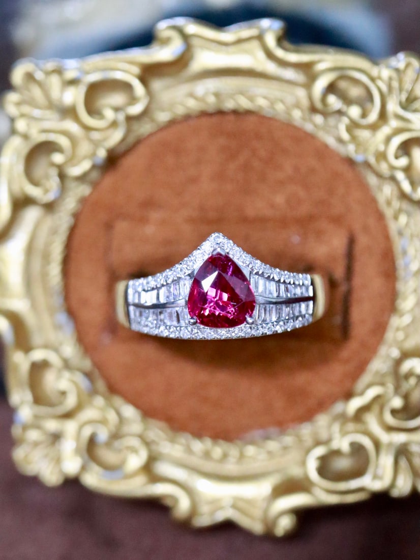 Platinum Natural Unheated Ruby Ring: This ring features a pear-shaped unheated ruby, complemented by diamonds, exuding a luxurious aura. The ruby's color is as intense as pigeon blood, captivating the heart. The overall design is