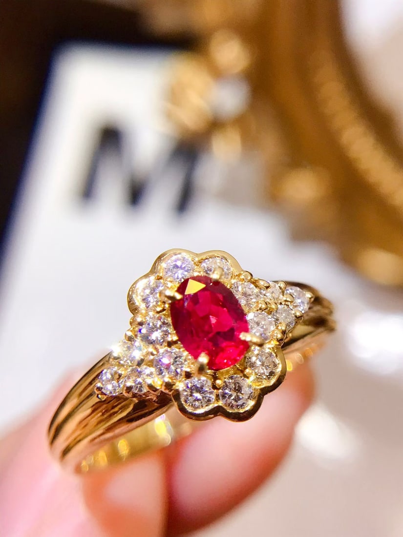 18K Gold Vivid Ruby Ring: This ring is meticulously set in 18K gold, featuring a vivid ruby that captivates with its vibrant hue. Complemented by diamond accents, the design is elegant and luxurious. The craftsmanship is
