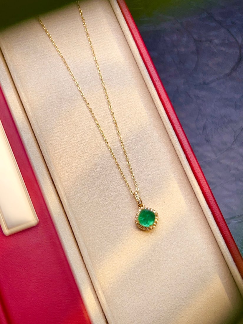 Natural Emerald Pendant: This emerald pendant, with its vivid green hue and classic diamond surround design, exudes timeless elegance. It highlights the wearer's noble temperament whenever worn. (Total weight: 0.76g; Main sto
