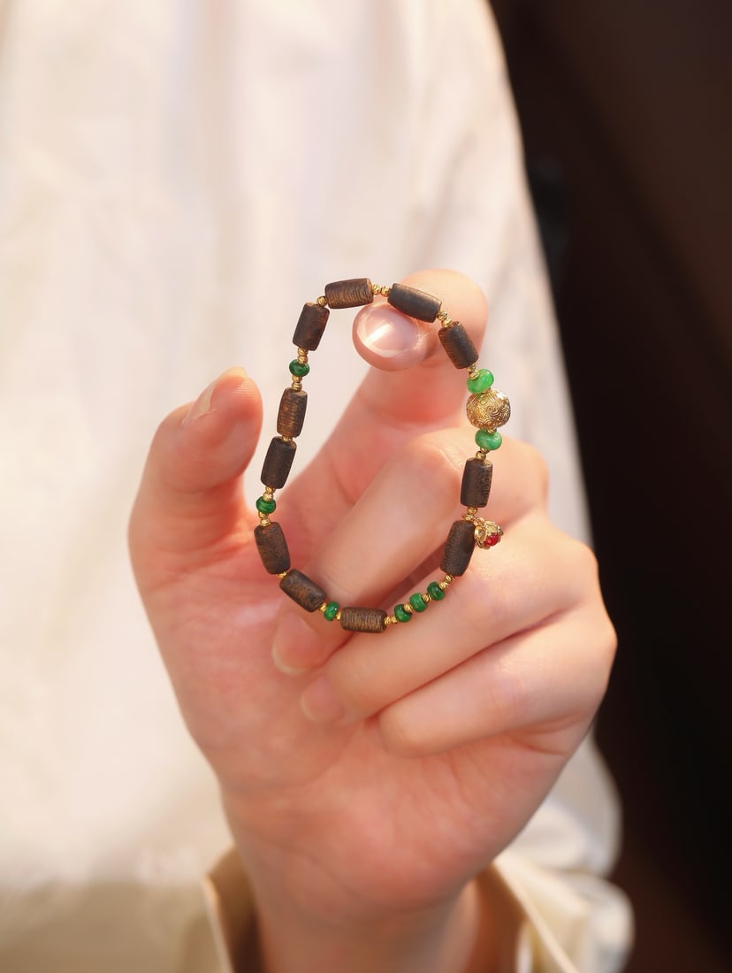 18K Gold Jadeite Bracelet: A harmonious blend of agarwood beads and jadeite, accented with small gold pieces and red corundum, showcasing a perfect fusion of elegance and vibrancy. Worn on the wrist, it exudes a unique charm