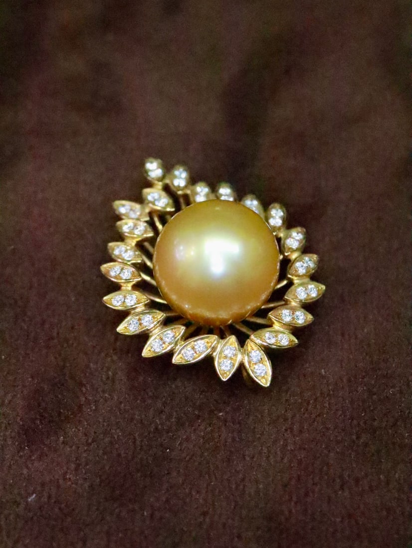 18K Gold Natural South Sea Golden Pearl Pendant: This pendant is meticulously crafted in 18K gold, featuring a natural South Sea golden pearl that is perfectly round and lustrous, exuding luxurious elegance. The diamond-set sides add a touch of