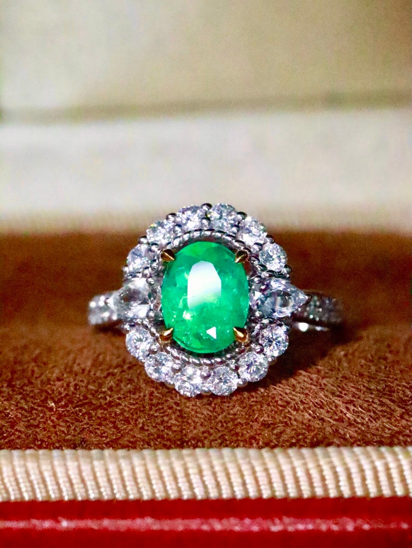 18K Gold Natural Emerald Ring: This ring is meticulously crafted in 18K gold, featuring a natural emerald that exudes elegance. Surrounded by a full circle of diamonds, it shines brilliantly and captivates the heart. The overall