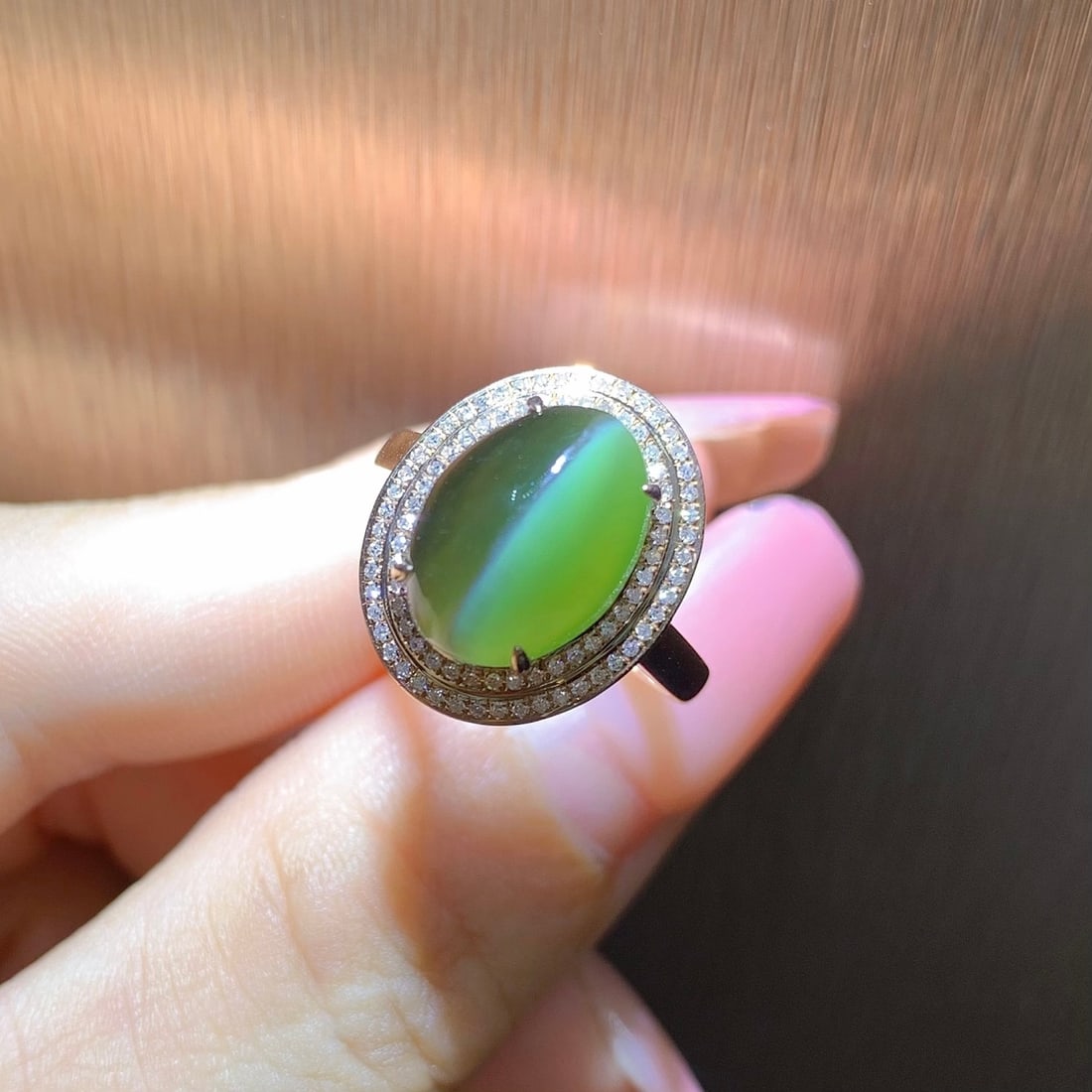 18K Gold Hetian Jade Cat's Eye Ring: This ring features a Hetian jade cat's eye set in 18K gold, showcasing a unique luster. The luxurious design with two circles of diamonds adds unparalleled opulence. The gemstone exhibits a distinctiv