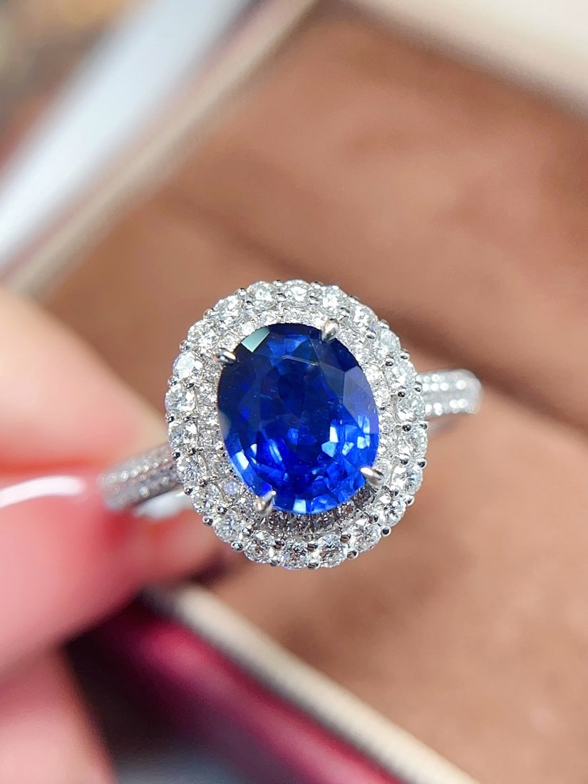 18K Gold Royal Blue Sapphire Ring: This ring is crafted in 18K gold, featuring a richly colored royal blue sapphire, showcasing a classic and elegant design. The glassy texture of the sapphire complements the brilliant fire of the diam