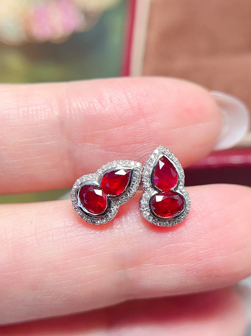 18K Gold Pigeon's Blood Red Ruby Earrings: These earrings are crafted in 18K gold, featuring a pigeon's blood red ruby in a classic gourd design. The rich hue of the ruby is complemented by exquisite diamonds, exuding luxury. The overall
