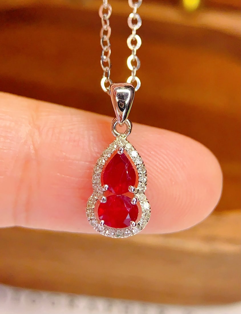 18K Gold Natural Ruby Pendant: This pendant is meticulously crafted in 18K gold, featuring a natural ruby that exudes an elegant and noble aura. The ruby's rich color is complemented by 26 sparkling diamonds, adding a touch of