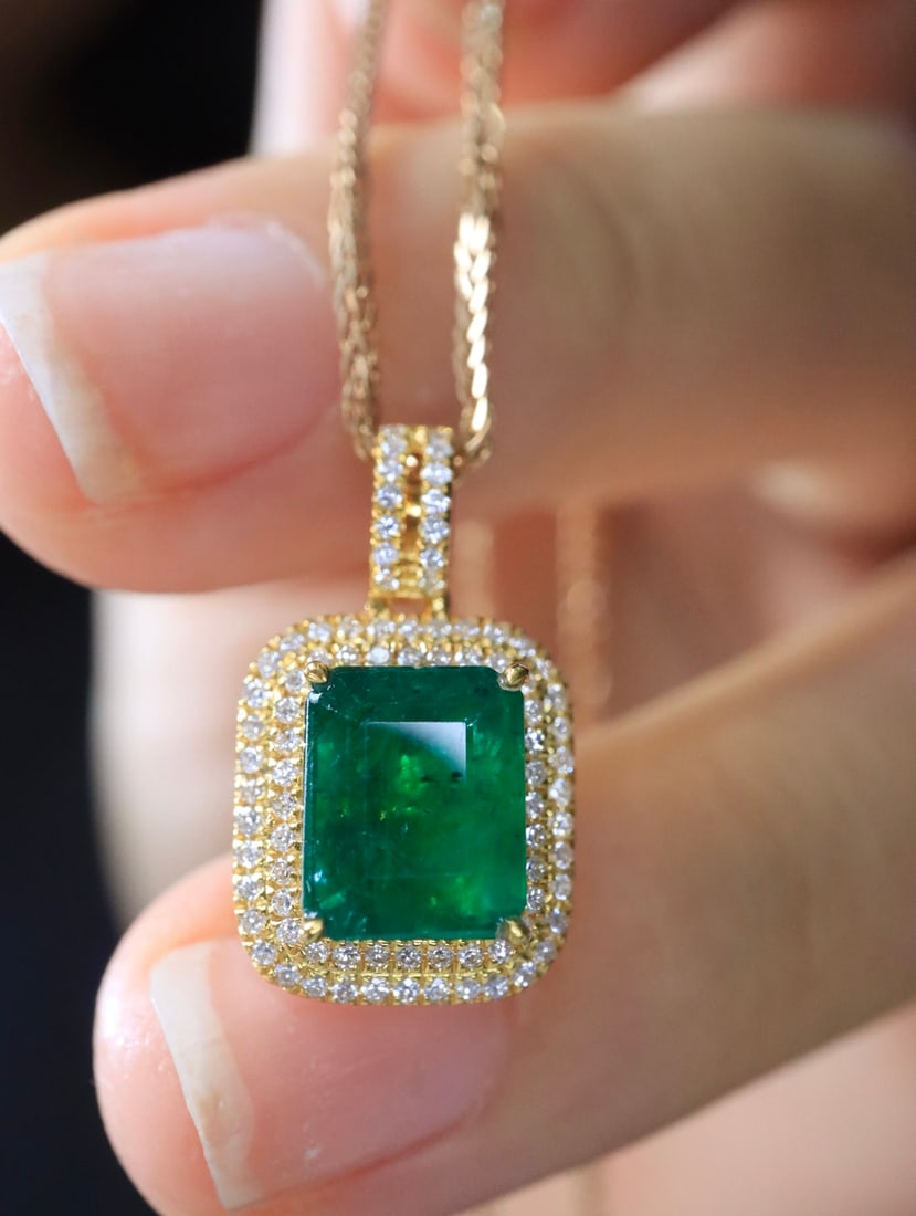 18K Gold Vivid Green Emerald Pendant: This pendant is meticulously crafted in 18K gold, featuring a vividly green emerald that exudes an aura of elegance and nobility. Complemented by sparkling diamonds, the design is simple yet