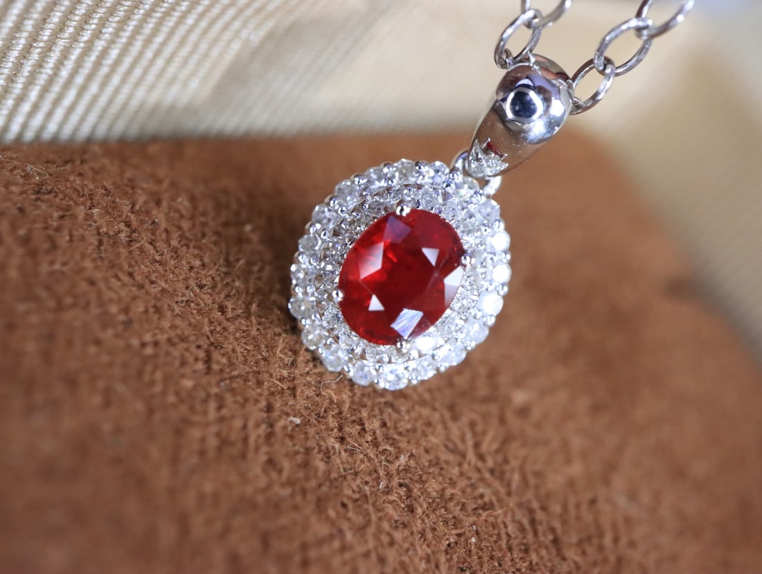 18K Gold Natural Pigeon Blood Ruby Pendant: This pendant is meticulously crafted in 18K gold, featuring a brilliant pigeon blood ruby, exuding classic elegance. The rich hue of the ruby, complemented by exquisite diamond accents, showcases a