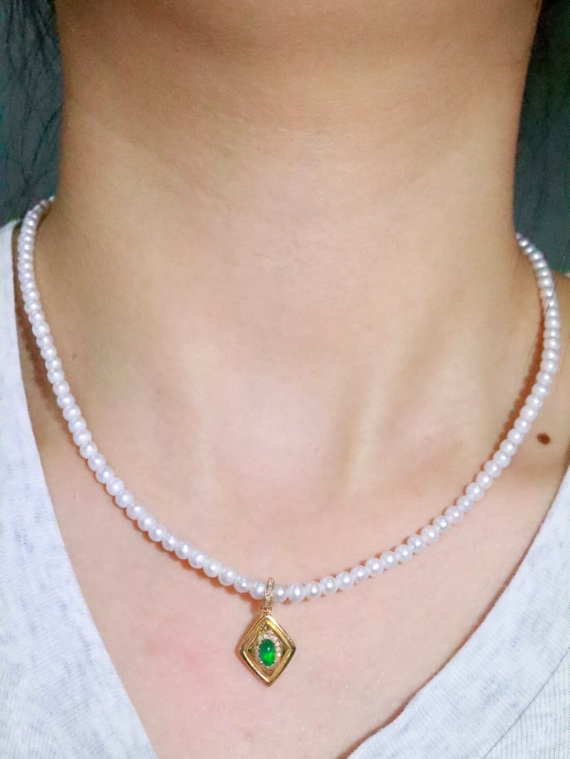 18K Gold Emerald Pendant: This 18K gold emerald pendant is exquisitely designed to pair with various necklaces and bracelets. The emerald's hue complements the brilliance of the diamonds, exuding an aura of elegance and