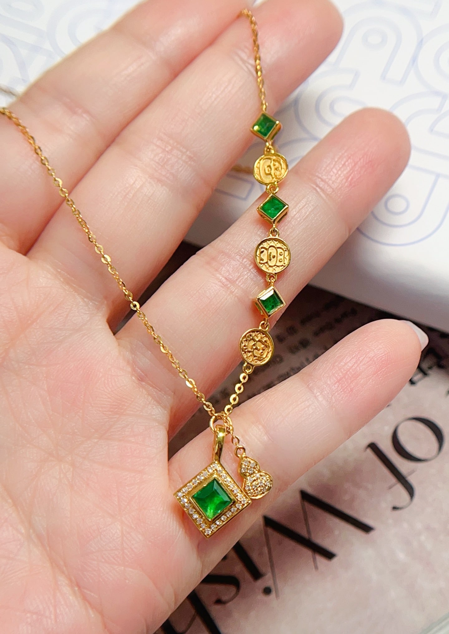18K Gold Emerald Necklace: This 18K gold necklace features an emerald as the main stone, showcasing its unique color charm. The playful and cute design is suitable for various occasions. Paired with diamonds, it adds a touch of