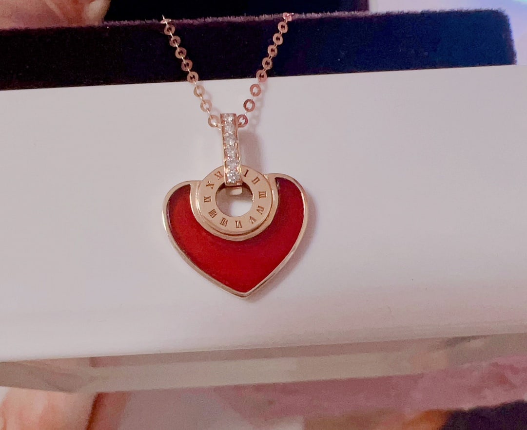18K Gold Natural Red Agate Diamond Necklace: This necklace features an 18K gold base, set with natural red agate and white mother-of-pearl. The heart-shaped design exudes romance, with sparkling diamonds adding an elegant touch.