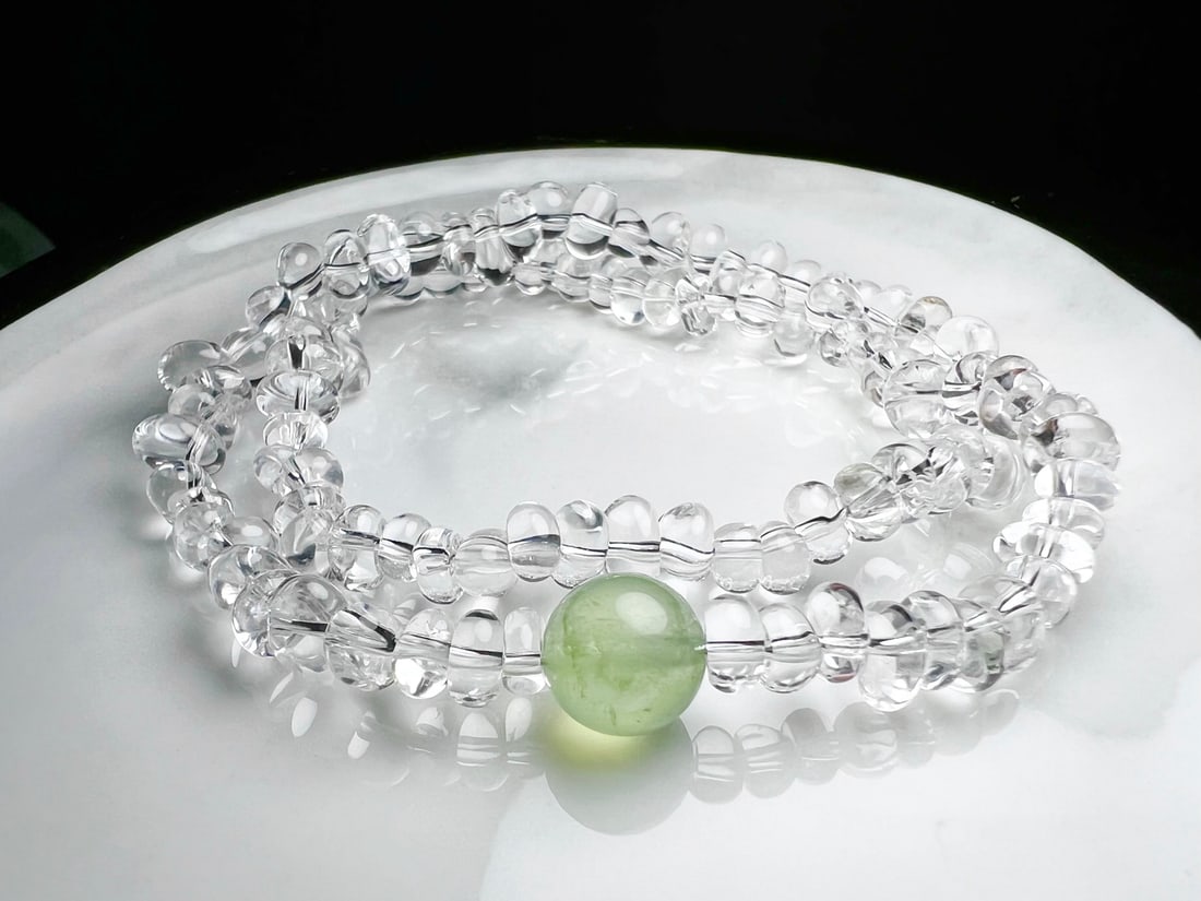 Natural White Crystal Prehnite Bracelet: This bracelet is meticulously crafted with natural white crystal and prehnite round beads, showcasing a harmonious beauty of nature. The clarity of the white crystal complements the softness of the