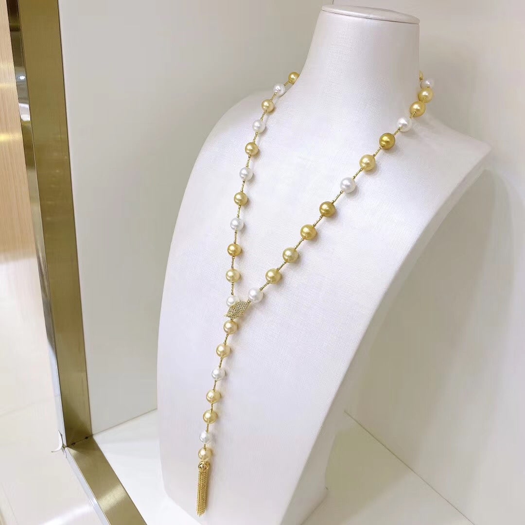 White and gold mixed pearl necklaceNecklace: This white and gold pearl necklace is renowned for its elegant mixed-color design, and its long length makes it suitable for pairing with various outfits. Feather clips and tassel details add a