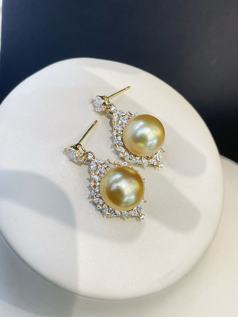 925 Silver Edison Pearl Earrings: These earrings are inspired by dynamic flame designs, featuring 12mm near-round warm golden Edison pearls with a soft satin luster. Surrounded by diamonds, they exude elegance in the play of light