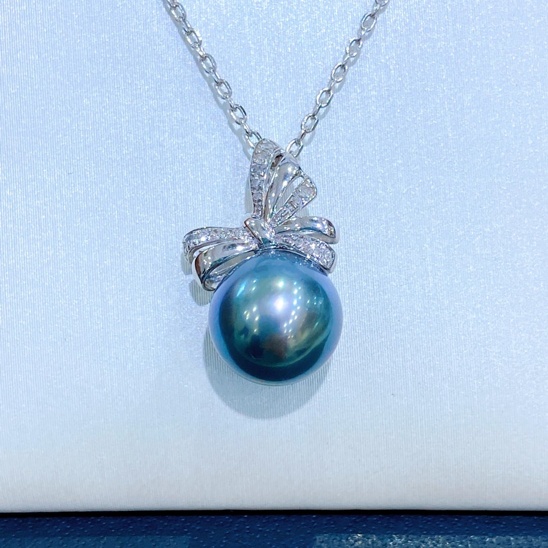 925 Sterling Silver Peacock Blue Pearl Pendant: This pendant features a peacock blue hue, showcasing a deep and lustrous shine. The flawless round design, paired with a delicate bow shape, adds a touch of elegance. (Main stone 11-12mm)