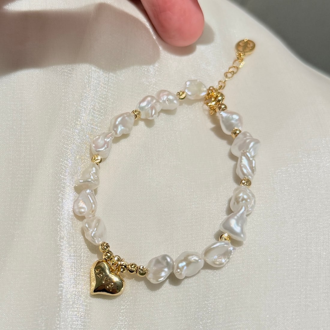 Baroque pearl bracelet: This bracelet features unique baroque pearls and an exquisite heart design, showcasing French elegance and sweetness. A Chrome Hearts chain pendant adds a touch of chic charm to the overall design.