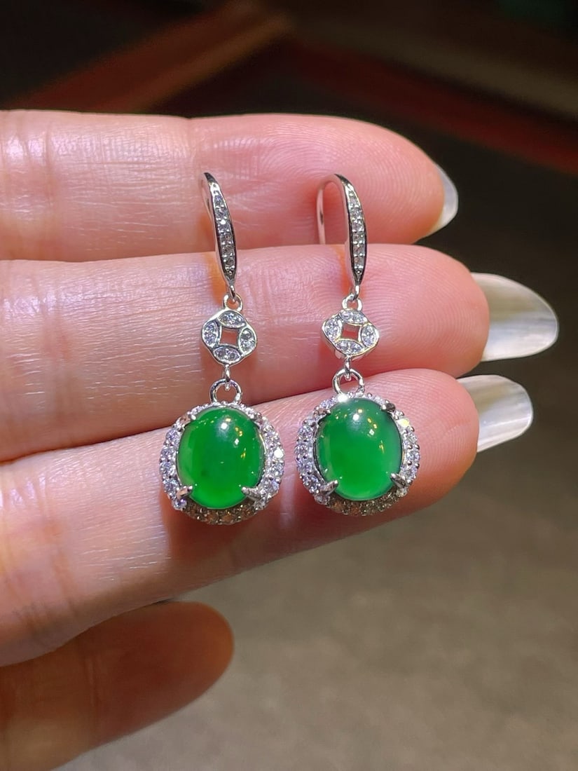 Silver Vivid Green Jadeite Earrings: These jadeite earrings feature a vivid green hue, full and perfect. Their simple yet elegant design makes them suitable for various occasions. The bare stone measures 9*7.5mm, highlighting the
