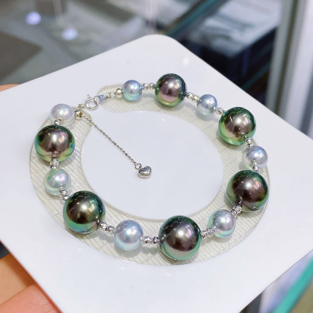 18K Gold Natural Tahitian Peacock Green Pearl Bracelet: This bracelet features natural Tahitian peacock green pearls with a captivating luster. Paired with true Madama pearls, it creates an elegant cool-toned contrast. The design is enhanced by 18K gold be