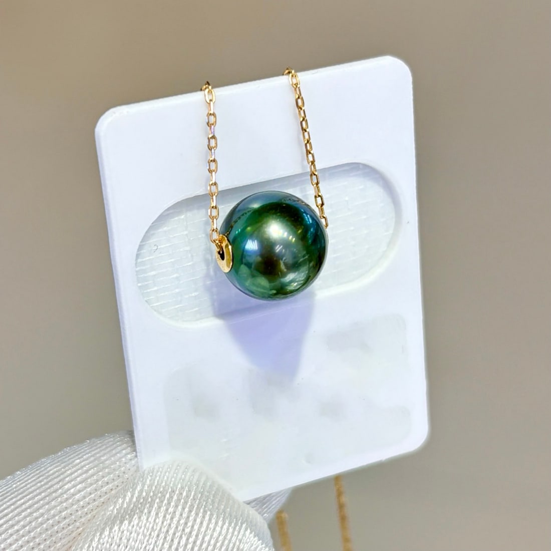 Natural Peacock Green Pearl Necklace: This pearl necklace boasts a captivating peacock green luster and features pearls that are 9-10 mm in diameter and perfectly round with minimal blemishes. Comes with a silver chain. (Pearls 9-10 mm in