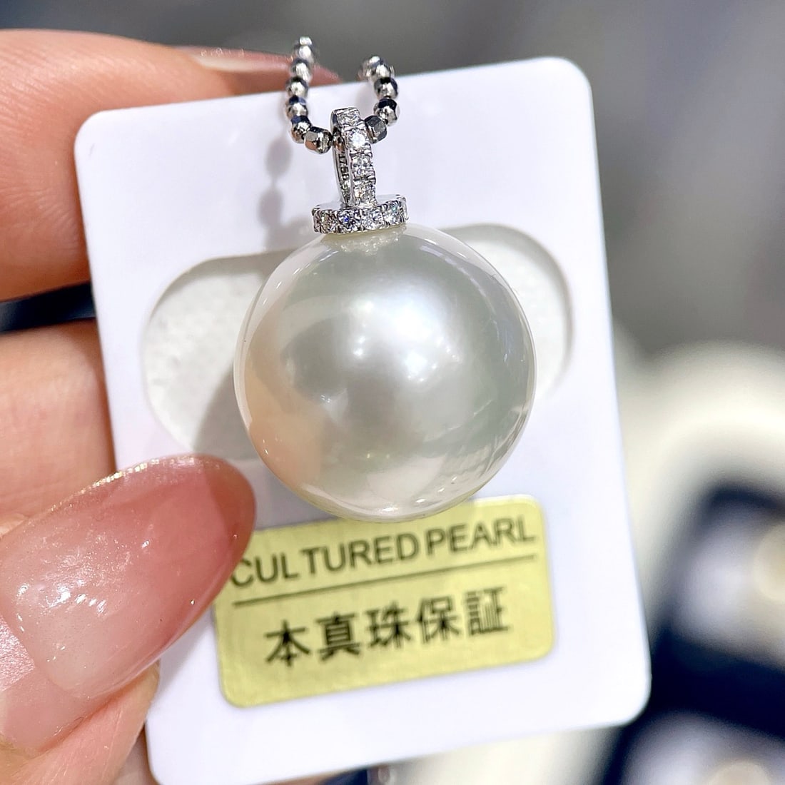 18K Gold Perfect Round Australian White Pendant: This pendant features a 17mm perfectly round Australian white pearl, emitting a cool white glow with a nearly flawless front. Paired with an 18K white gold clasp, it exudes elegance and nobility. (Pea